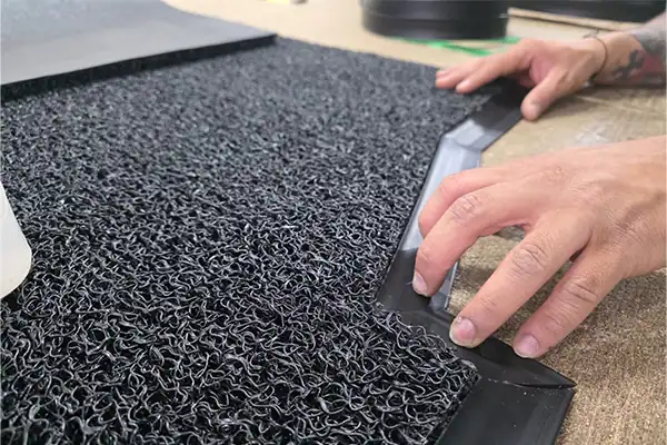 Perfilado de bordes para tapete personalizado en fábrica de tapetes Bogotá