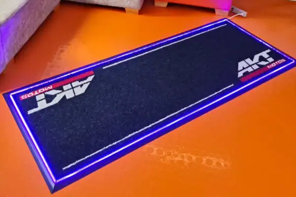 Tapete publicitario luminoso para exhibición de motos AKT y Metzeler con iluminación LED
