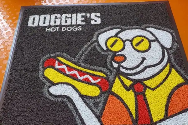 Tapete publicitario con logo en entrada de negocio — publicidad que todos ven